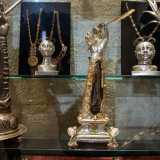 � posto in un reliquiario argenteo anch�esso a forma di arto superiore con una piuma dorata, alla cui base sono presenti dei puttini e la data in cui venne donato alla basilica: il 1679